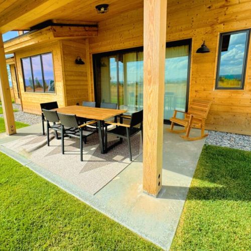 The backyard features a dining area, a firepit, and plenty of seating to enjoy the beautiful view.