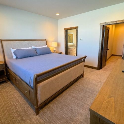 The primary bedroom features a king bed, TV, spacious closet, and is connected to a large en suite bathroom.