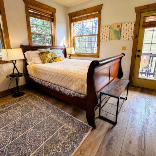 Bedroom #2 has a comfy queen bed, a wall-mounted TV, and access to a balcony shared with Bedroom #3.