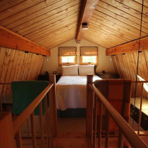 Light pours through the windows over the cozy bed.