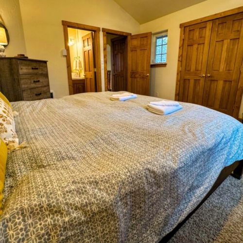 The master bedroom features a king bed, a dedicated work station with a computer monitor, and an en suite bath.