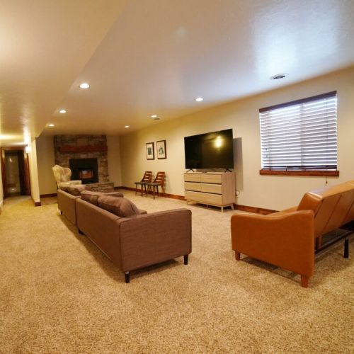 Downstairs is an enormous living room, complete with a smart TV, fireplace, and games.