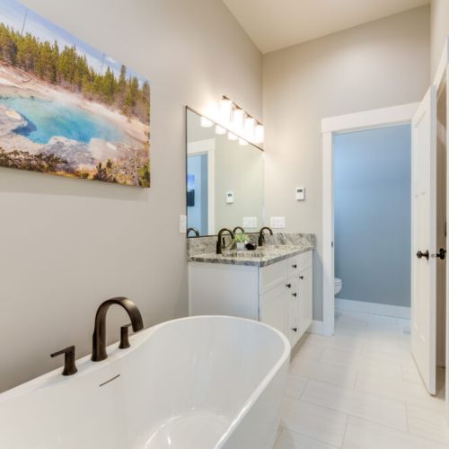 The primary en suite enjoys a spacious double vanity, a luxurious step-in shower, and a soaking tub.