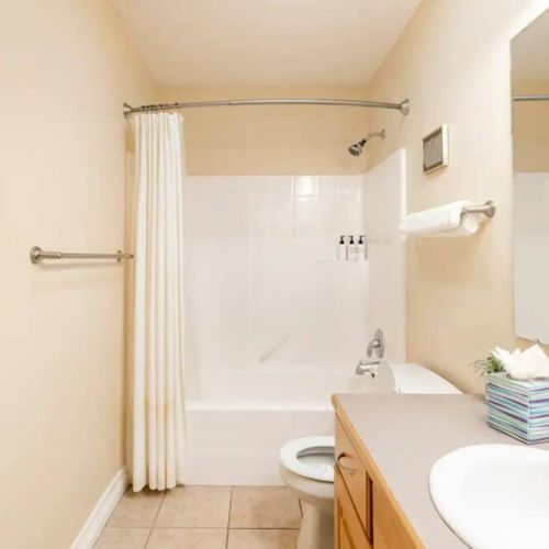 Bedrooms #2 and #3 share a bathroom. Located just off the hallway, it has a vanity, a large mirror, and a tub/shower combo.