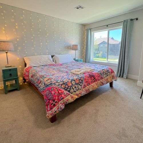 The spacious primary bedroom enjoys a king bed, a large walk-in closet, a flat-screen TV, and an en suite bathroom.