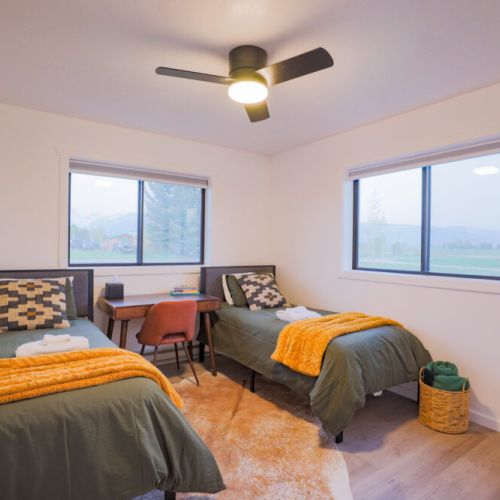 Bedroom #3 has two twin beds, a closet, a desk, and a view of the Tetons.