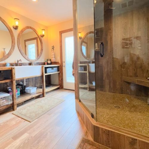 The primary en suite enjoys an expansive double vanity, a walk-in shower, and  direct access to a private hot tub.