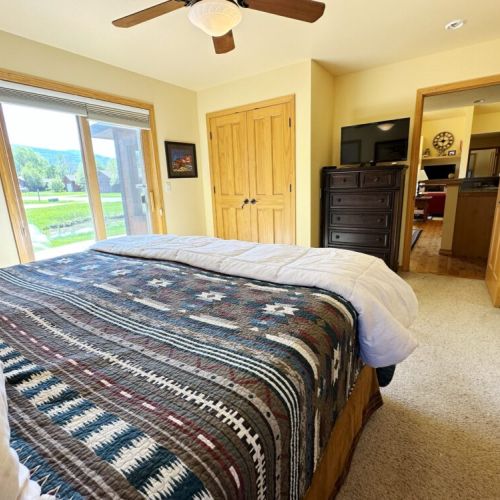 The master bedroom features a king bed, direct access to the back porch, a TV, and an en suite bath.