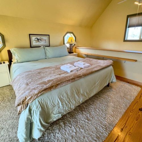 Upstairs is home to a king bed, a balcony facing the mountains, and a half-bath.