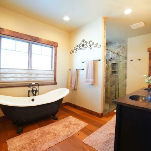 The master bath has a walk-in shower with his-and-hers shower heads. There is also a beautiful tub, three sinks, and plenty of space to store toiletries or other items.