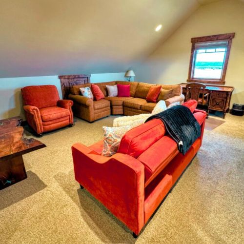 The upstairs features another common area, a pullout sofa bed, and a desk for work- or school-from-home.