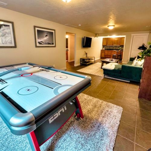 The basement game room comes equipped with a smart TV, a dry bar, and an air hockey table.