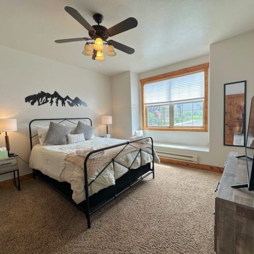 The master bedroom has a queen bed, a terrific window seat,  a TV, and an en suite bath.
