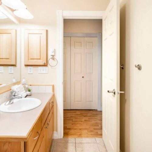 Bedrooms #2 and #3 share a bathroom. Located just off the hallway, it has a vanity, a large mirror, and a tub/shower combo.