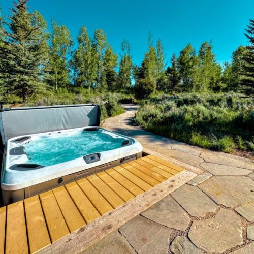 The backyard features a hot tub and a propane fire pit.
