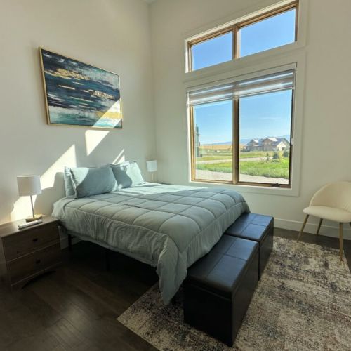 The bedroom features a queen bed, a spacious closet, and a peek of the Tetons.