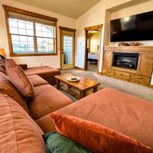 Kickback at the end of a day of skiing, hiking, or biking by relaxing in the cozy living room, complete with custom cabinetry and an electric fireplace.