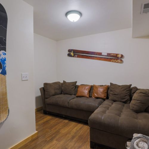 Head downstairs to enjoy a cozy living area, complete with an inviting sectional and a TV.