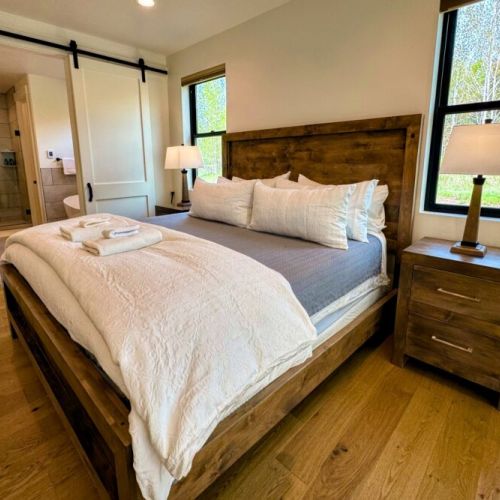 The ground-floor master bedroom enjoys a king bed, a large en suite bathroom, and direct access to the backyard (including a path directly to the hot tub).