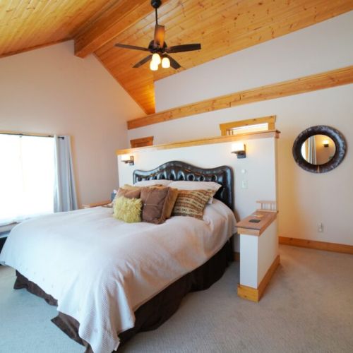 The master bedroom, located on the main floor of the home, features a king bed, an en suite bathroom, and a sauna.