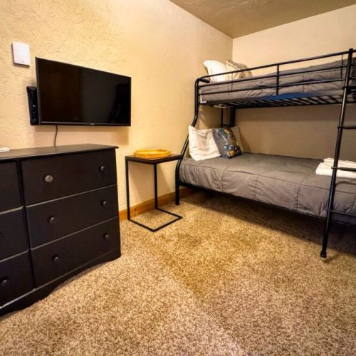 Down in the basement, bedroom #3 enjoys a twin-over-full bunk bed and an attached half-bath, as well as a TV — perfect for kids!