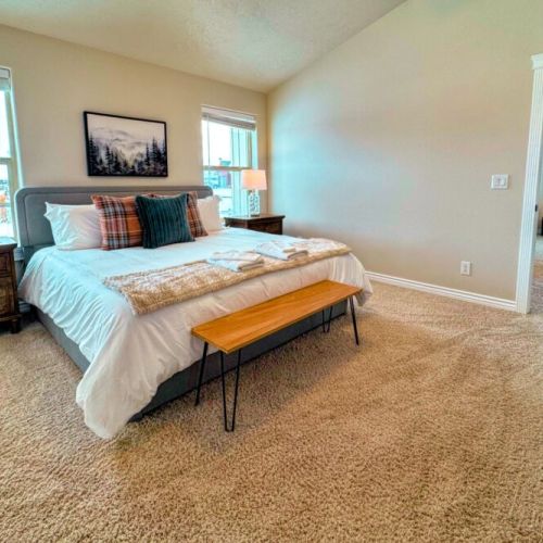 The primary bedroom features a king bed, a large en suite bathroom, and a walk-in closet.