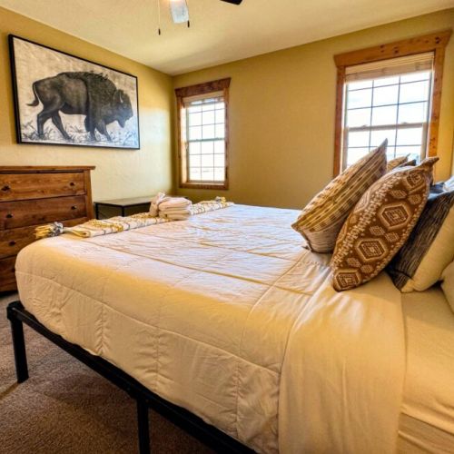 The primary bedroom enjoys a king bed with a custom Teton headboard. It also has an en suite bath and a desk for those who need to work-from-home.