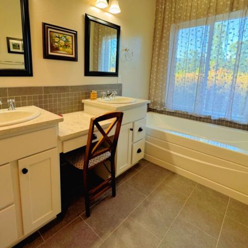 The primary en suite enjoys a spacious double vanity, a luxurious tub, and a step-in shower.
