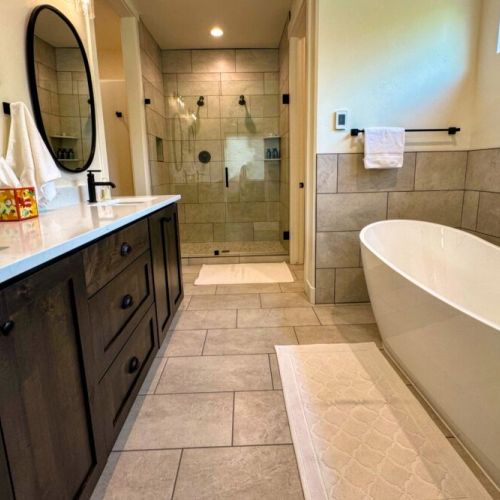 The ground floor master en suite has a spacious double vanity, a walk-in shower, a soaking tub, and a walk-in closet.