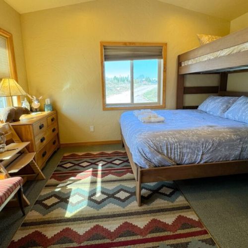 The downstairs bedroom features a twin-over-queen bunk bed, a closet, and a TV.