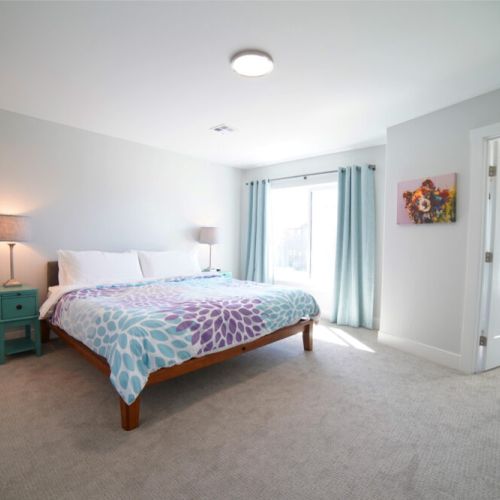 The spacious master bedroom enjoys a king bed, a large walk-in closet, a flat-screen TV, and an en suite bathroom.