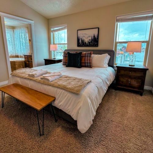 The primary bedroom features a king bed, a large en suite bathroom, and a walk-in closet.