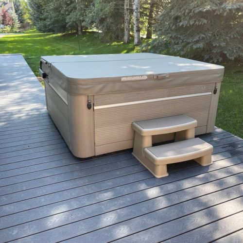 The hot tub is situated on a deck with a gate for privacy.