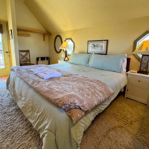 Upstairs is home to a king bed, a balcony facing the mountains, and a half-bath.