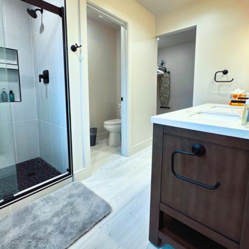 The primary en suite bathroom enjoys a step-in shower, a spacious double vanity, access to the walk-in closet, and a private water closet.