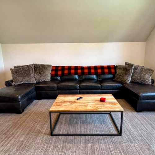 The entertainment room is located upstairs — featuring a large sectional, big wall-mounted TV, and its own en suite bathroom, this is the perfect hangout space.
