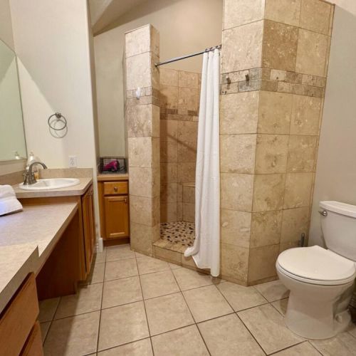 The upstairs bathroom has a large vanity, a walk-in shower, and plenty of storage place.