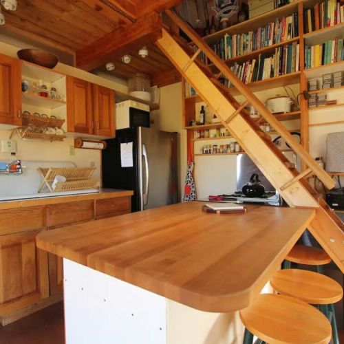 The rustic kitchen features a farm sink, fridge, and ample seating/dining space. (There is no microwave, dishwasher, or garbage disposal.)
