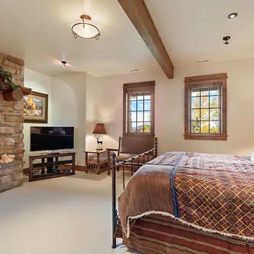 The master bedroom (located on the lower level) features a king bed, gas fireplace, TV, and an en suite bathroom with a shower/tub.
