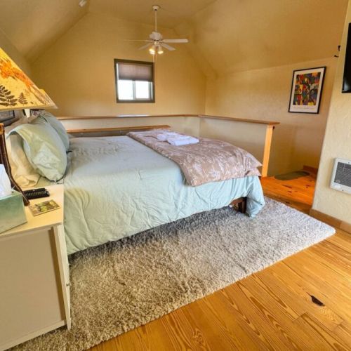 Upstairs is home to a king bed, a balcony facing the mountains, and a half-bath.
