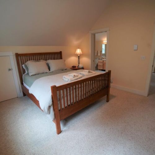 Upper bedroom has a queen bed and direct access to upper full bath.