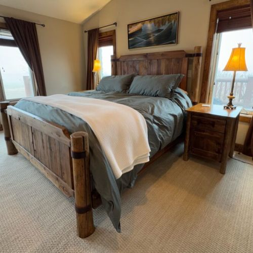 The primary bedroom features a king bed, a gas fireplace, a smart TV with a soundbar, a large en suite bathroom, and access to a private hot tub.
