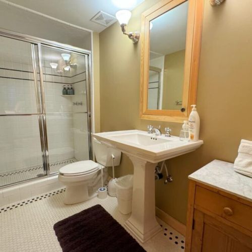 Bedroom #5, located in the basement, has a queen bed, twin-over-twin bunk bed, and an en suite bath.