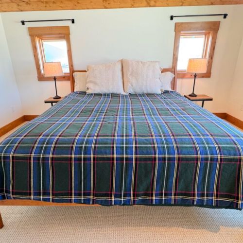 The primary bedroom (located upstairs) features a king bed, a walk-in closet, an en suite bathroom, and a direct view of the Tetons.