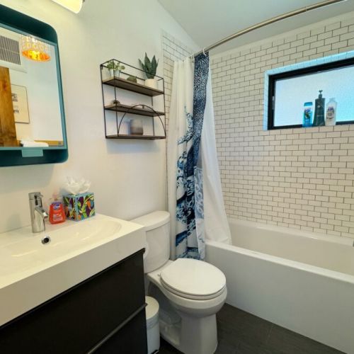 The chic bathroom features a lovely vanity and a spacious tub/shower combo.