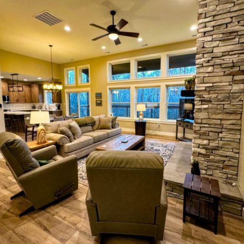 The spacious open-concept living area with vaulted ceilings, cozy seating, and seamless flow leads straight to the dining room and kitchen.