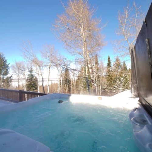 The hot tub is just outside the dining area on the deck, featuring gorgeous views overlooking Teton Valley.