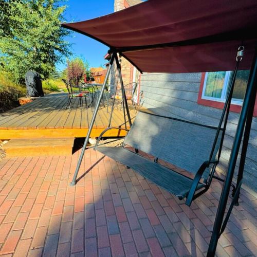 The backyard, which butts up against Ski Hill Road, has a cozy porch with a propane grill and comfy seating options.