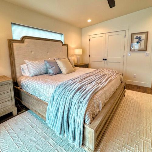 The primary bedroom features a king bed, views of the Tetons, a smart TV, and an expansive en suite bathroom.