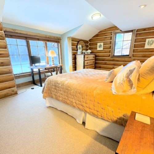Bedroom #3, also located on the main level, has a queen bed, a dedicated workspace, and an en suite bathroom.